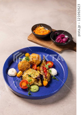 Gourmet vegan dish served on blue plate with side dishes Gourmet vegan dish served on blue plate with side dishes 121092623
