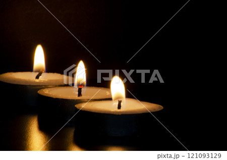 Candles shining in the dark representing religious prayer moment with customizable space for message, text or ideas. 121093129