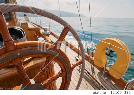 Travel, ocean and wheel on boat for cruise, luxury sailing and transport for holiday, vacation and trip. Travelling, summer and yacht in sea for tropical journey on seascape background or environment Travel, ocean and wheel on boat for cruise, luxury sailing and transport for holiday, vacation and trip. Travelling, summer and yacht in sea for tropical journey on seascape background or environment 121094350