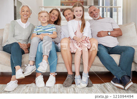 Portrait of a happy family sitting on the couch in the living room at home. Joyful little girl and boy bonding with parents and grandparents in the living room. Grandparents visiting grandchildren Portrait of a happy family sitting on the couch in the living room at home. Joyful little girl and boy bonding with parents and grandparents in the living room. Grandparents visiting grandchildren 121094494