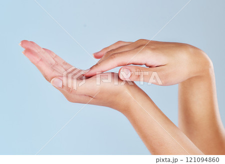 Closeup of female hands touching her palm. One woman with soft, flawless, moisturized skin isolated on a blue background. Elegant fingers showing manicure and hygiene. A skincare and beauty treatment Closeup of female hands touching her palm. One woman with soft, flawless, moisturized skin isolated on a blue background. Elegant fingers showing manicure and hygiene. A skincare and beauty treatment 121094860