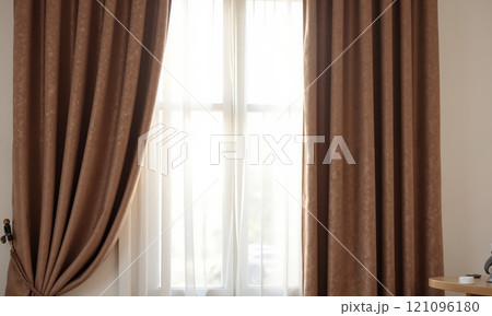 A mocha mousse-colored velvet curtain, hanging elegantly over a tall window with sheer white drapes 121096180