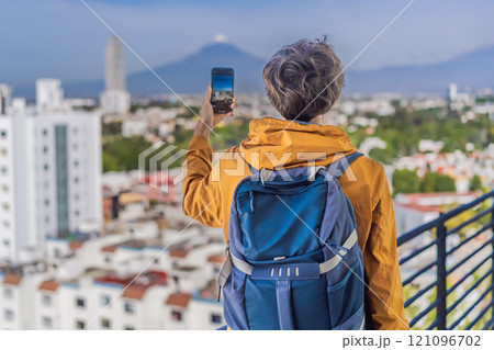 Male tourist in front of Popocatepetl Volcano, Mexico. Adventure, natural exploration, and travel experience concept 121096702