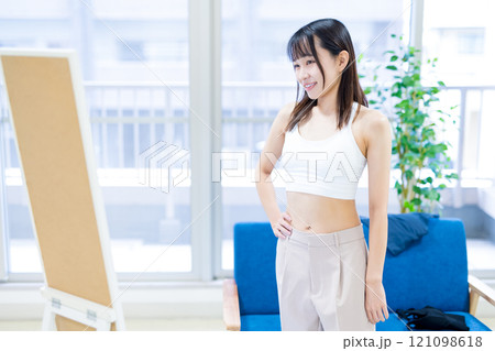 姿見鏡の前で洋服と下着を選ぶ若い女性　スポーツブラ　下着選び　 121098618