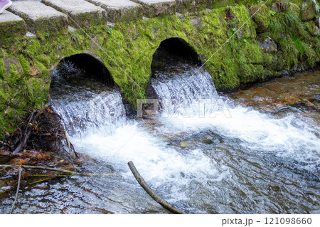 Ginzan onsen, Yamagata, Japan, Water flowing from moss-covered drainage pipes into a stream 121098660