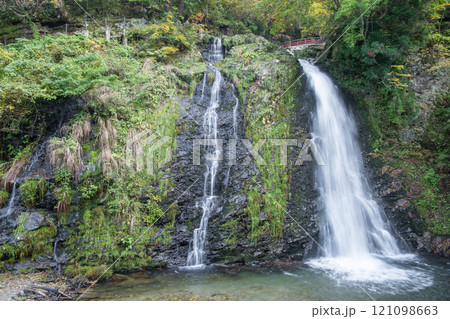 Ginzan onsen, Yamagata, Japan, Serene waterfall cascading over lush greenery. Ginzan onsen, Yamagata, Japan, Serene waterfall cascading over lush greenery. 121098663