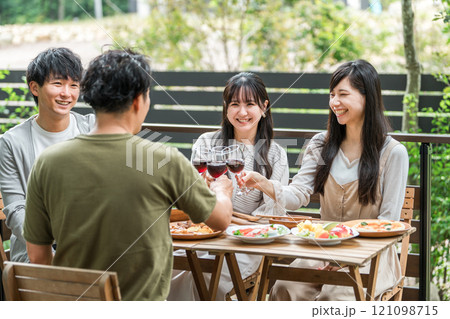 ウッドデッキでホームパーティー・グランピングする若いアジア人男女グループ 121098715