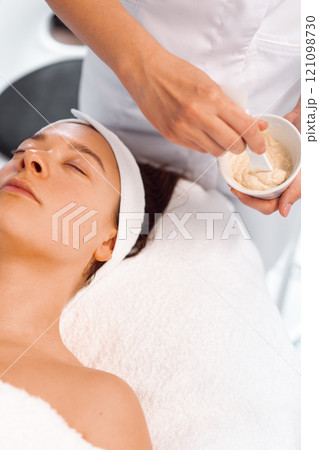 Dermatologist preparing face mask for female 121098730