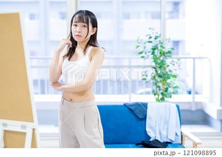 姿見鏡の前で洋服と下着選びを迷う若い女性　スポーツブラ　下着選び　 121098895