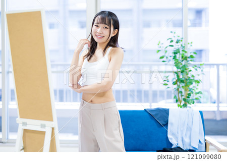 姿見鏡の前で洋服と下着選びをする笑顔の若い女性　スポーツブラ　下着選び　 121099080