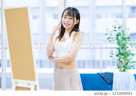 姿見鏡の前で洋服と下着選びをする笑顔の若い女性 スポーツブラ 下着選び トリミングアップ 姿見鏡の前で洋服と下着選びをする笑顔の若い女性 スポーツブラ 下着選び トリミングアップ 121099081