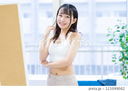 姿見鏡の前で洋服と下着選びをする笑顔の若い女性 スポーツブラ 下着選び トリミングアップ 姿見鏡の前で洋服と下着選びをする笑顔の若い女性 スポーツブラ 下着選び トリミングアップ 121099082