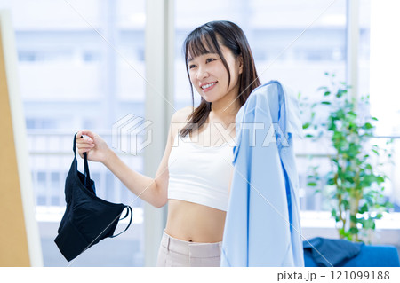 姿見鏡の前で洋服と下着を選ぶ笑顔の若い女性 スポーツブラ 下着選び 姿見鏡の前で洋服と下着を選ぶ笑顔の若い女性 スポーツブラ 下着選び 121099188