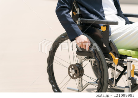 スーツ姿の車椅子ユーザーの手元 121099983