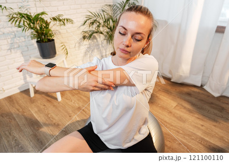 A woman stretching sideways in a bright, minimalist room 121100110