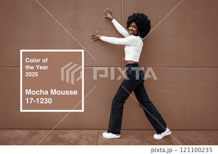 Woman posing by a brown wall showcasing new trendy fashion and the color of the year for 2025 121100235