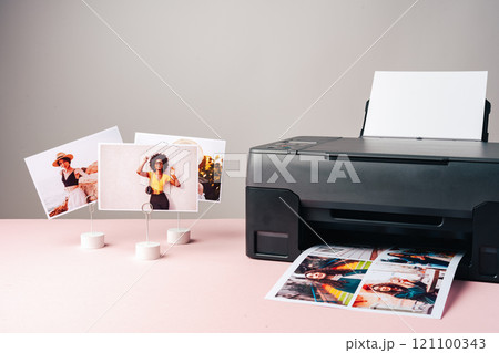 Modern laser printer printing color photos of women close up 121100343
