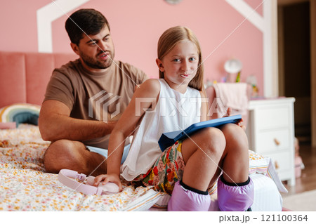 Father and daughter share a playful moment together in cozy bedroom Father and daughter share a playful moment together in cozy bedroom 121100364