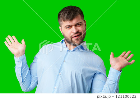 A man playfully posing with a quirky expression against a bright green background 121100522