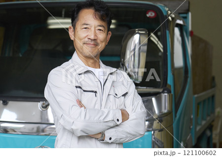 トラックの前に立つ男性作業員のポートレート カメラ目線 トラックの前に立つ男性作業員のポートレート カメラ目線 121100602