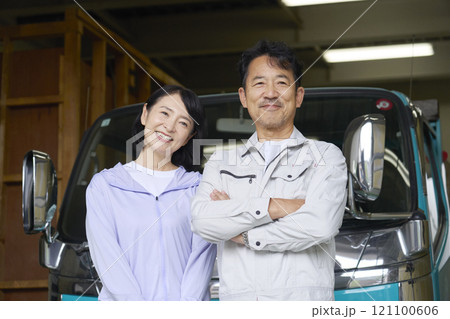 トラックの前に立つ作業員の夫婦のポートレート トラックの前に立つ作業員の夫婦のポートレート 121100606