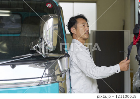 トラックの横に立つ男性作業員のポートレート トラックの横に立つ男性作業員のポートレート 121100619