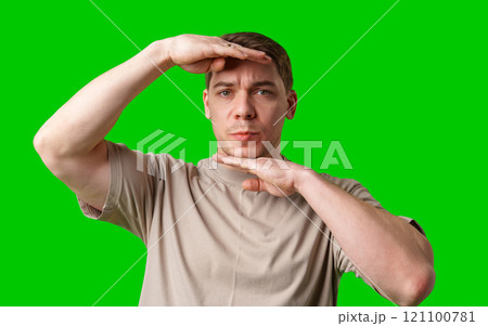 A man with short hair poses against a vibrant green background A man with short hair poses against a vibrant green background 121100781