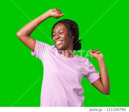 A young woman with braids expresses excitement with a clenched fist against a bright green background 121100790