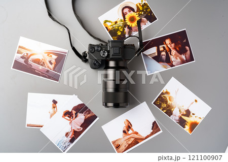 Photo camera with colorful printer photos on gray desk Photo camera with colorful printer photos on gray desk 121100907