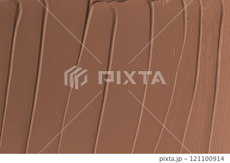 Smooth, creamy texture of rich chocolate frosting spread across a surface in warm brown tones 121100914