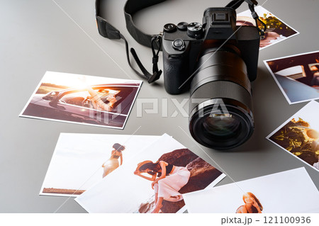 Photo camera with colorful printer photos on gray desk 121100936