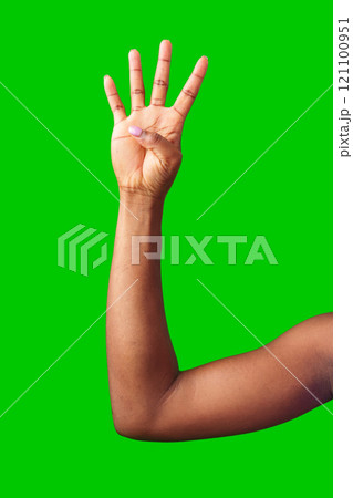 A hand making a gesture with a green background during daylight A hand making a gesture with a green background during daylight 121100951