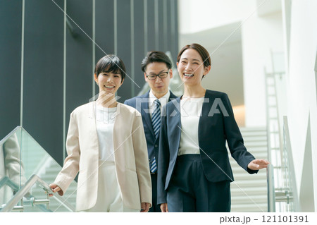 オフィスの階段を下るスーツ姿の男女 オフィスの階段を下るスーツ姿の男女 121101391