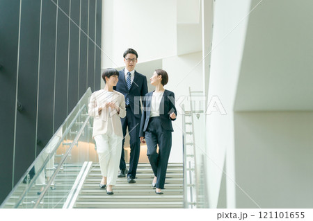 オフィスの階段を下りるスーツ姿の男女 オフィスの階段を下りるスーツ姿の男女 121101655
