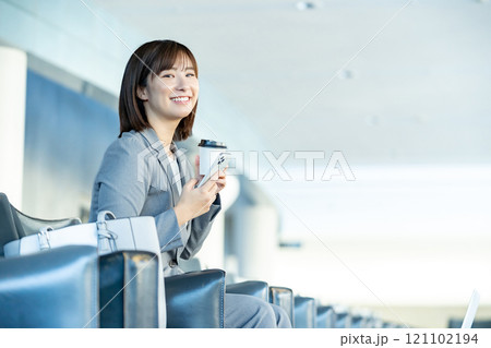 スマホを見るOL 空港のロビーで誰かを待つ女性 OL 働くオフィスレディ スマホを見るOL 空港のロビーで誰かを待つ女性 OL 働くオフィスレディ 121102194