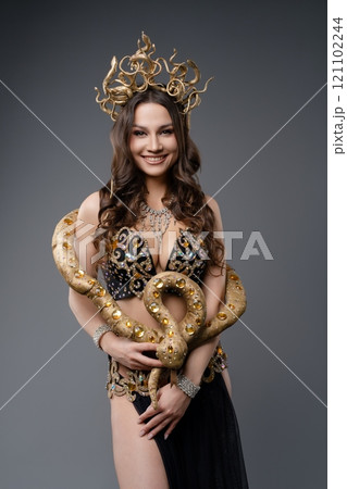 Belly dancer wearing a snake costume performs in an elegant setting 121102244