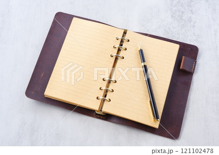 リング式のシステム手帳を開いてデスクワークをしているイメージ リング式のシステム手帳を開いてデスクワークをしているイメージ 121102478