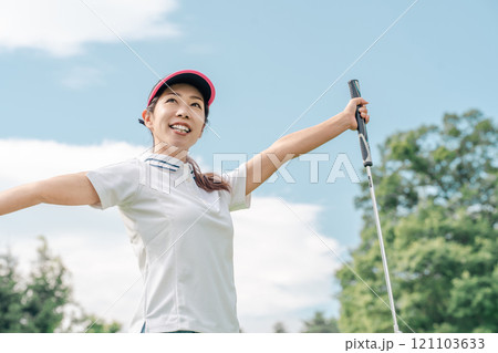 ゴルフ場でゴルフをするゴルフウェアを着たゴルファーの女性（ガッツポーズ） 121103633