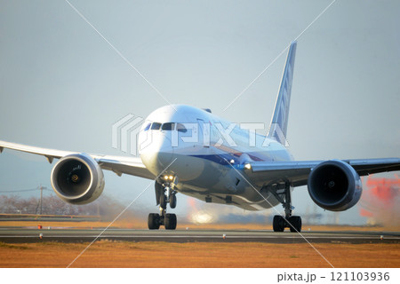 朝陽を浴びて離陸する旅客機 121103936