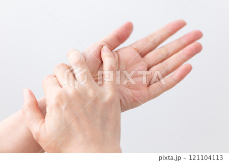 保湿のハンドクリームを塗ってスキンケアをするミドル〜シニア女性の手元 121104113