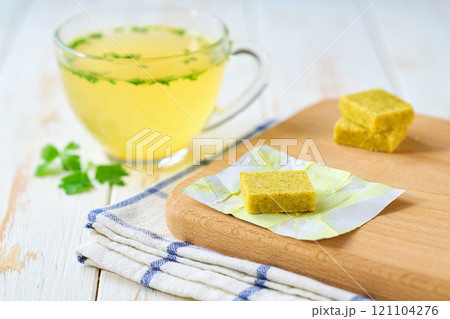 bouillon cube with ready to eat bouillon in a bowl on a white table. 121104276