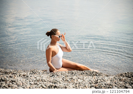 Freelance close up woman hands writing on computer. Well looking middle aged woman typing on laptop keyboard outdoors with beautiful sea view. 121104794