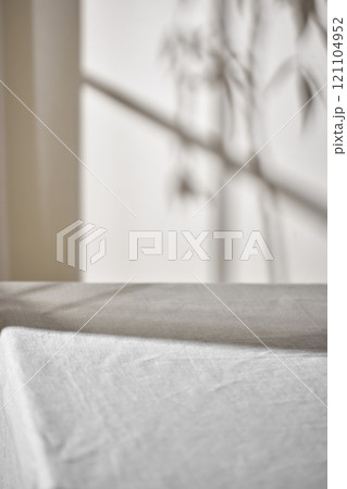 Warm sunlight streaming in through the window, beige background, flowers, vases, and a table with plants. Harmony of light and shadow. Warm sunlight streaming in through the window, beige background, flowers, vases, and a table with plants. Harmony of light and shadow. 121104952