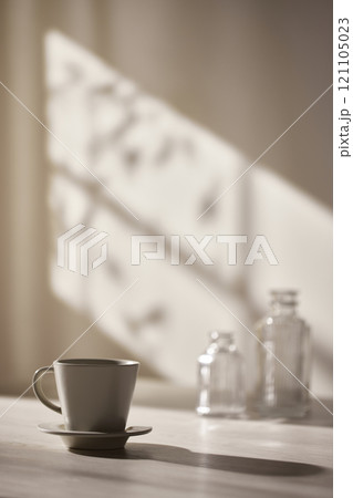 Warm sunlight streaming in through the window, beige background, flowers, vases, and a table with plants. Harmony of light and shadow. Warm sunlight streaming in through the window, beige background, flowers, vases, and a table with plants. Harmony of light and shadow. 121105023