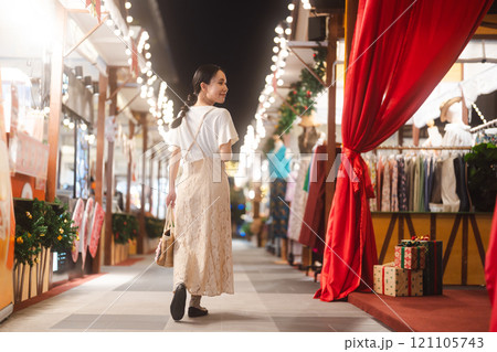 Asian woman walking at outdoors market on Christmas and happy new year holidays Asian woman walking at outdoors market on Christmas and happy new year holidays 121105743