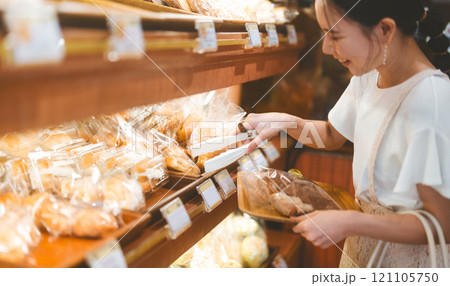 Happy smiling customer asian woman choosing whole grain bread at bakery shop 121105750