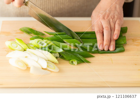 長ネギを切る女性の手元 121106637
