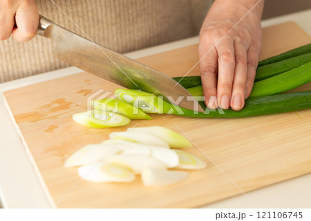 長ネギを切る女性の手元 121106745