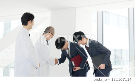 握手をする医者と営業職の男性 握手をする医者と営業職の男性 121107114