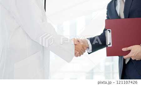 握手をする医者と営業職の男性 121107426